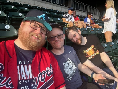 From left to right sitting in the stands at Truist Park in Atlanta, GA: Brandon, Mike Tarpey, Bryant.